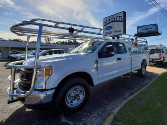 Polished aluminum full-length rack installed on a Ford Super Duty at a dealership.