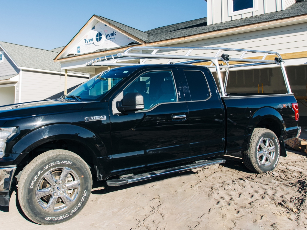 Ford F-150 parked at a new home build with a polished rack installed.