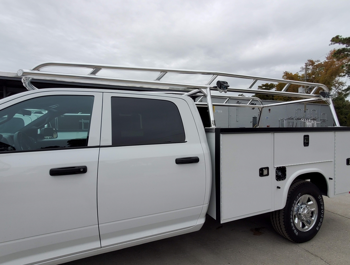 Close side angle highlighting the aluminum rack mounted on a white Knapheide utility body.