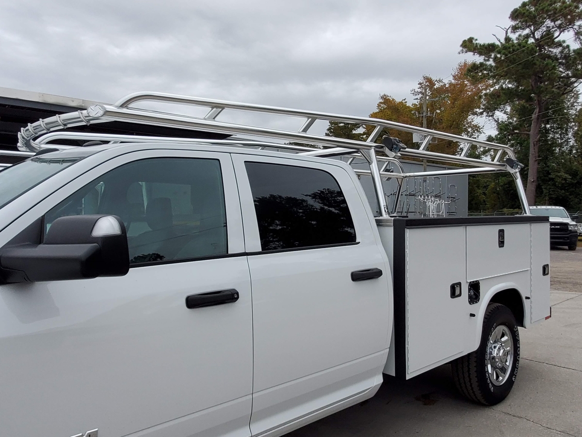 Side view of a Ram service truck showing the over-cab aluminum rack and utility compartments.