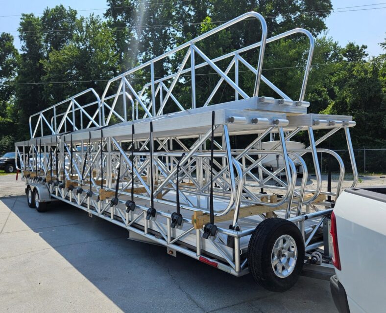 Multiple built‑to‑order aluminum gangways stacked on a trailer ready for regional delivery