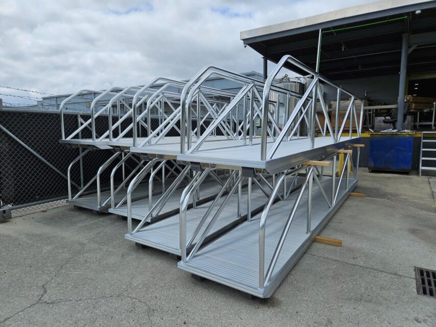 Close‑up view of custom aluminum gangways stacked for bulk order, showing handrails and non‑slip decks