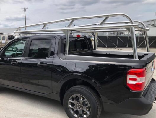 Driver-side view of a Ford Maverick ladder rack showing curved uprights and welded crossbars.