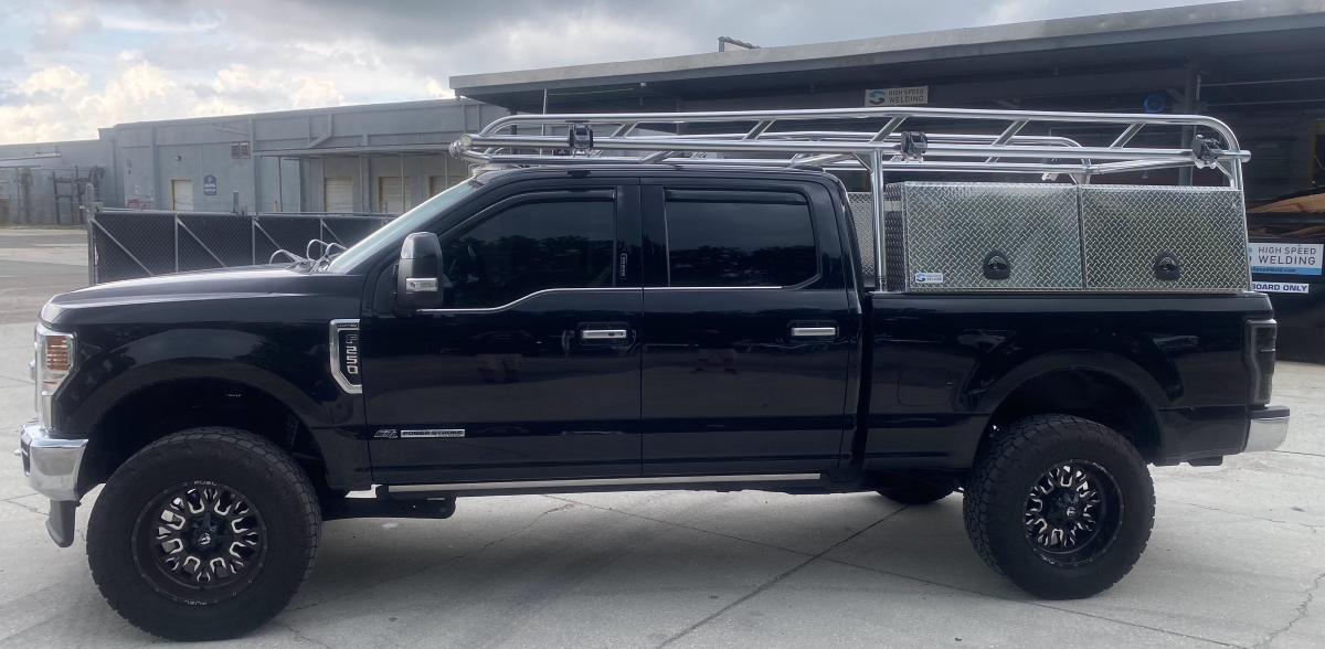 Full side view of a black Ford F-250 Super Duty featuring a welded Ryder Rack and Topsider tool box