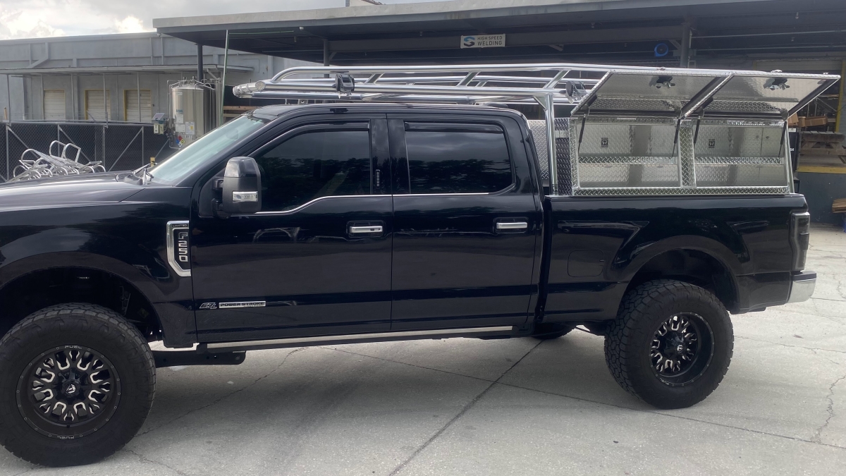 Driver-side view of a Ford F-250 Super Duty showing Ryder Rack WELD system and Topsider tool boxes with both lids open.