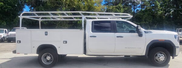 Passenger-side view showing the welded aluminum service body ladder rack installed on a GMC Sierra HD with a Knapheide body.