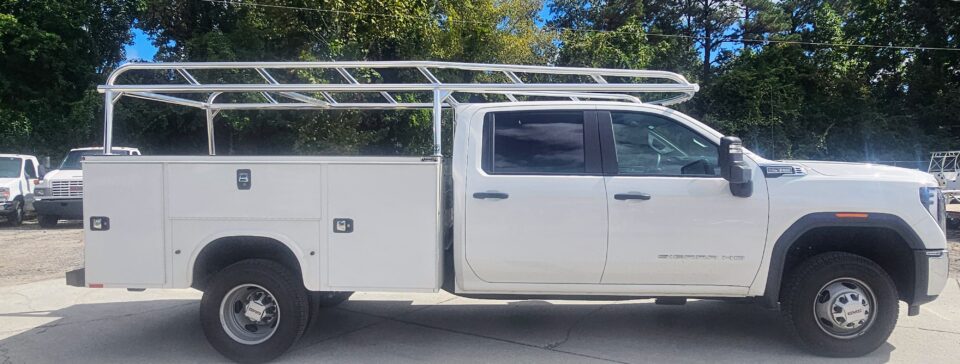 Passenger-side view showing the welded aluminum service body ladder rack installed on a GMC Sierra HD with a Knapheide body.