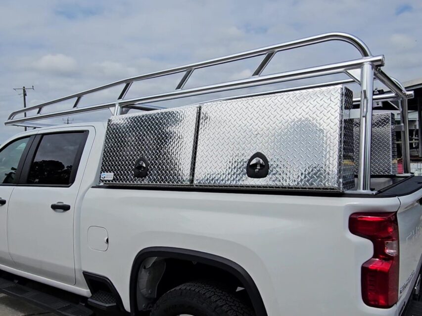 Rear angled view of the anodized aluminum ladder rack with tool boxes mounted above the bed rails.
