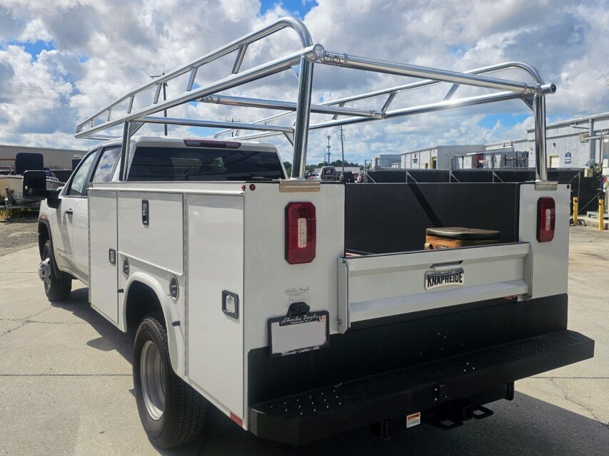 Polished aluminum Ryder Rack Service Series installed on a Knapheide service body, rear-angle view on a GMC Sierra HD.