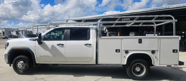 Full side profile of a GMC Sierra HD with a Knapheide service body and welded aluminum Ryder Rack ladder rack.