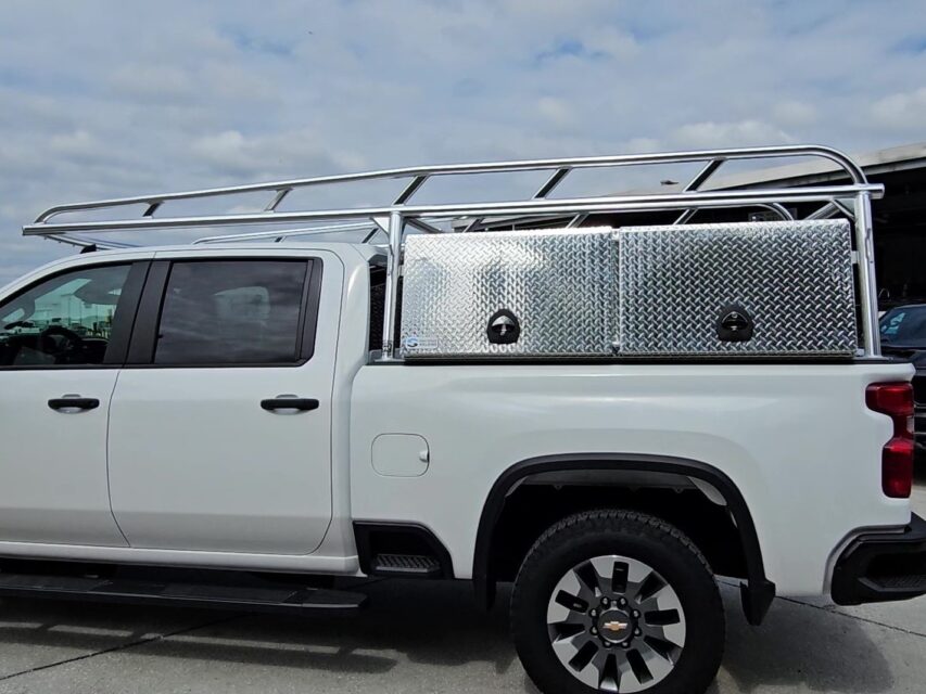 Side view of the anodized aluminum ladder rack with tool boxes installed on a Chevy 2500 HD.