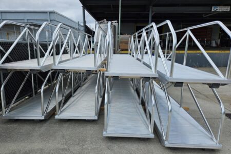 Stack of welded aluminum dock gangways with handrails at High Speed Welding facility