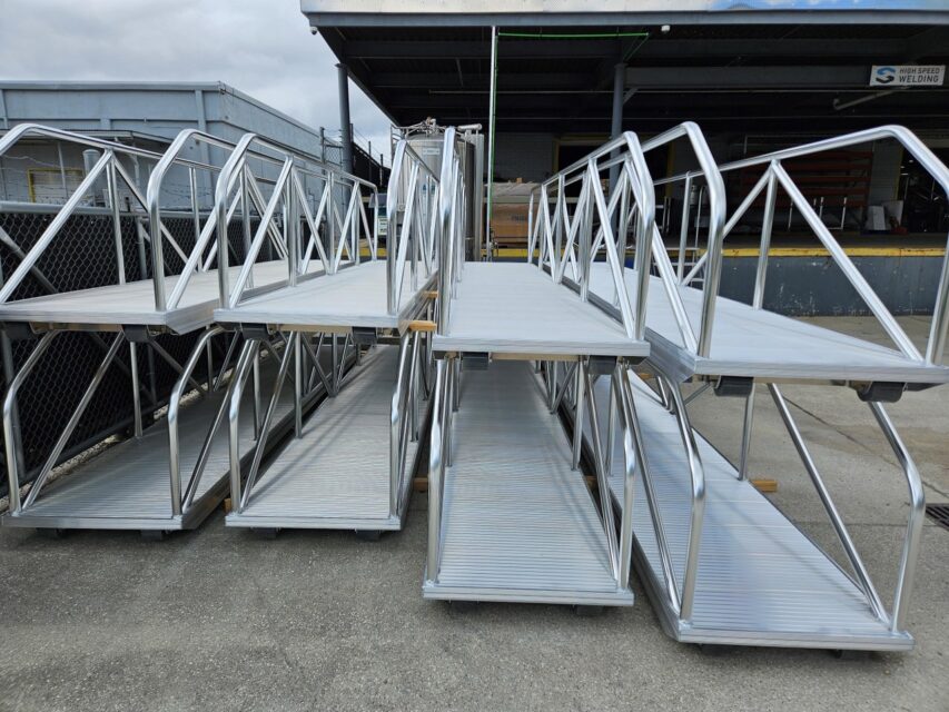 Stack of welded aluminum dock ramps with handrails at High Speed Welding facility