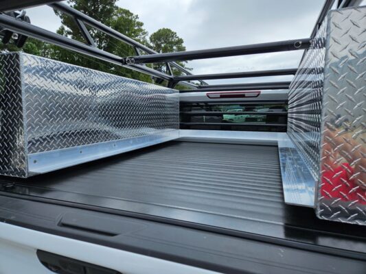 Bed interior showing the XL topsider tool boxes and the custom welded frame above the cover.