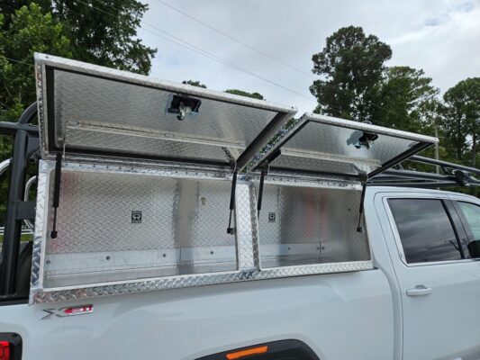Open XL topsider tool boxes under a ladder rack with tool boxes on a GMC Sierra.